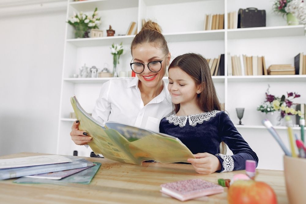 orientadora educacional auxiliando aluna em uma atividade escolar.