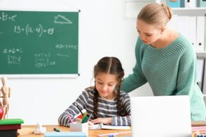 orientadora educacional auxiliando aluna em uma atividade escolar.