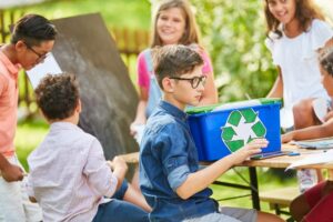 alunos realizando atividade ao ar livre sobre reciclagem e meio ambiente.