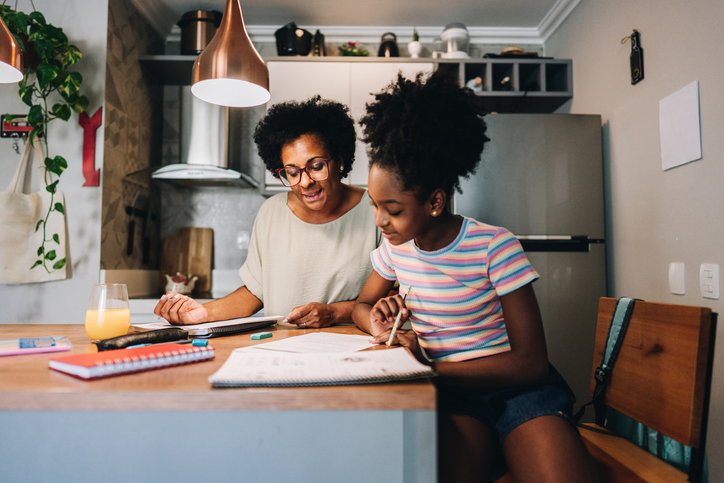 criança estudando inglês em casa com a família